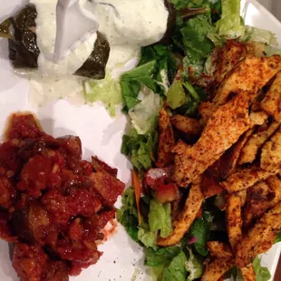 Grilled chicken plate with stuffed grape leaves and roasted eggplant