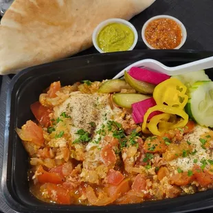 Shakshouka, sauces, and pita.