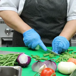 a woman cutting vegetables on a cutting board
