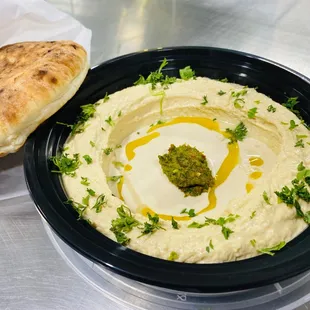 a bowl of hummus and bread
