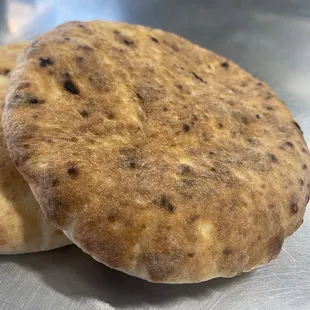 two flatbreads on a metal surface