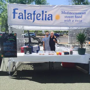 two people standing behind a table