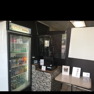 a coffee shop with a refrigerator and a table