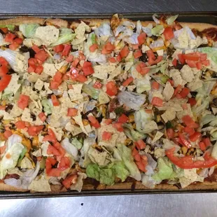 We also have specialty pizzas like this one! Delicious taco pizza that is served with salsa and sour cream!