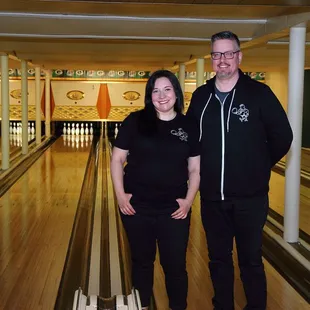 a man and a woman standing in a bowling alley