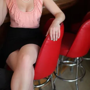 a woman sitting at a bar drinking a drink