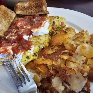 Mexican omelet (onion, tomato, green pepper, chorizo, jalapeño, cheddar), topped with sour cream and salsa, with home fries, wheat toast.