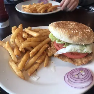 a man eating a burger and french fries