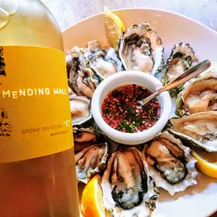 a plate of oysters and a bottle of wine