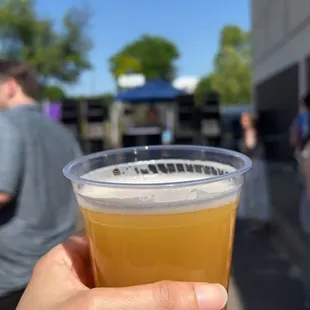a person holding a cup of beer