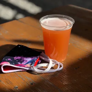 a cup of beer and a napkin on a table