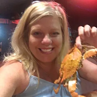 a woman holding up a crab