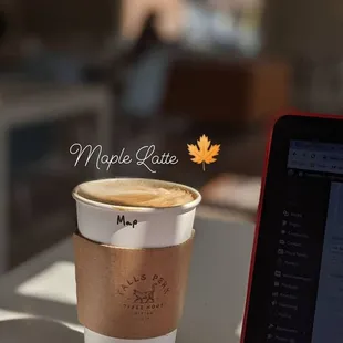 a cup of coffee next to a laptop