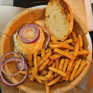 Fallston BYO Burger with fresh onions, cheese, bacon, fried egg, and fries.