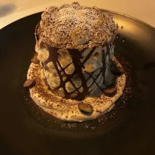 a chocolate covered dessert on a black plate