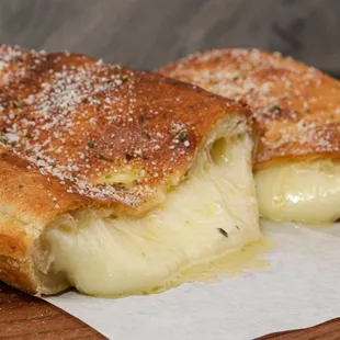 two pieces of bread with cheese and sauce