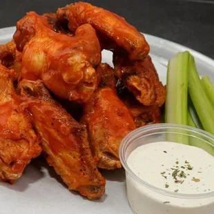 a plate of chicken wings and celery sticks