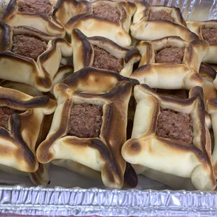 a tray of meat and cheese buns