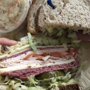 a sandwich and coleslaw on a paper plate