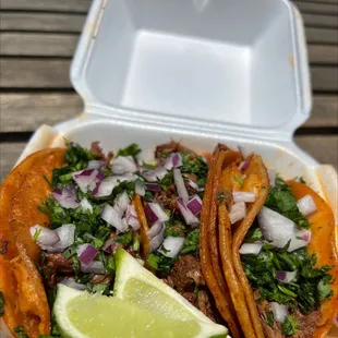 two tacos in a styrofoam container