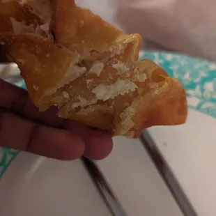 a person holding a pastry with a bite taken out of it