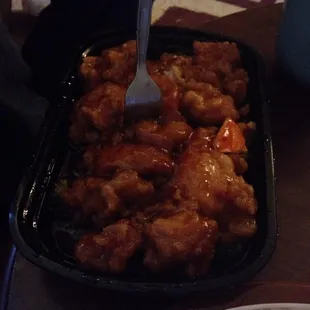 Large portion of orange chicken with orange peels.
