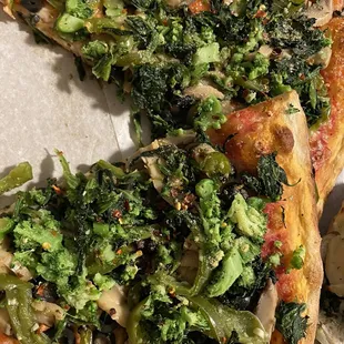 a slice of pizza with broccoli