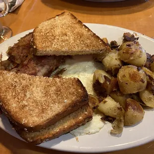 a plate of food with toast, eggs, and potatoes