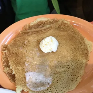 a plate of pancakes with butter and syrup