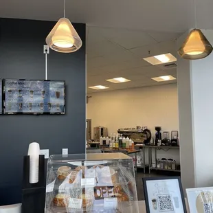 a coffee shop counter with a display of pastries