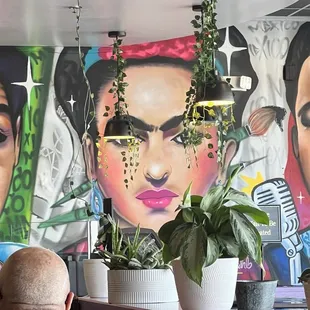 a man sitting in front of a mural