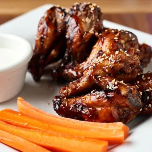 a plate of chicken wings and carrots