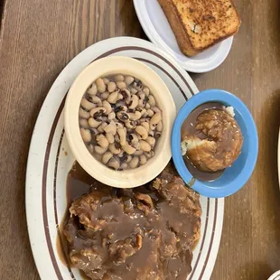 Country fried steak baked potatoes and black eyed peas with garlic toast
