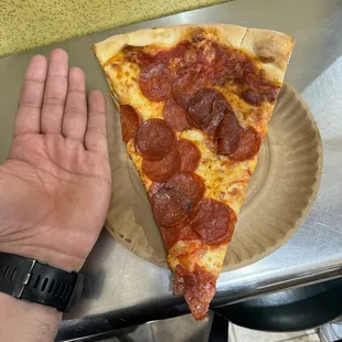 Pepperoni slice with my hand as comparison