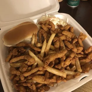 Fried clam strips with fries, coleslaw, and a dinner roll.