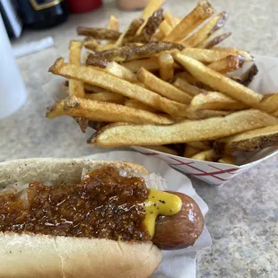 Delicious Boars Head Hotdog with chili and onions and fresh cut fries.