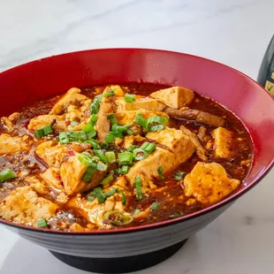 a bowl of food and a bottle of sauce
