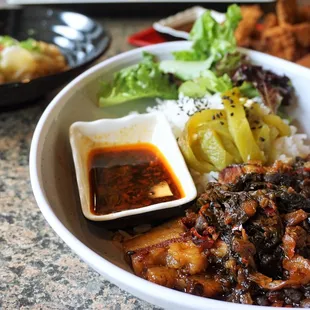 Mei Cai Pork Belly Bowl (梅菜蒸肉盖码饭): pork belly slow cooked with house chili sauce and Mei Cai, served with roasted pepper and rice ($15.75).