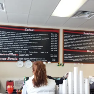 a woman standing in front of a menu