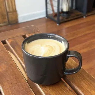 a cup of coffee on a wooden table