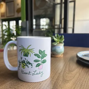 a white coffee mug with a plant lady on it