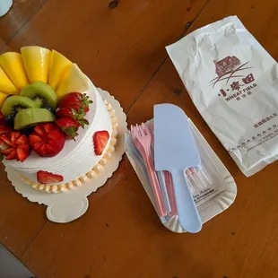 Small fruit cake, comes with 8 candles, plates, fork, and knife