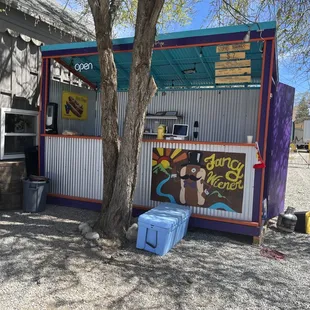 a food stand with a tree in front of it