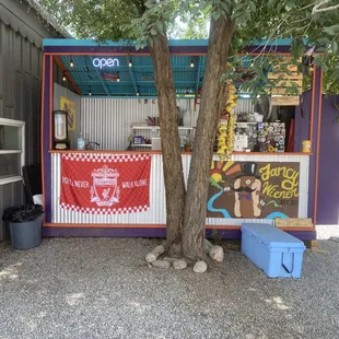 a food stand with a tree in front of it