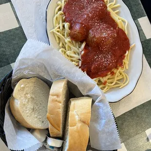 Spaghetti with meatball and sausage and a basket of killer good bread