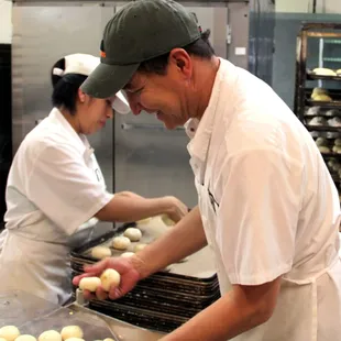 two bakers preparing doughnuts