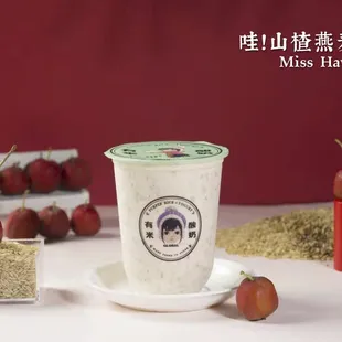 a cup of yogurt with cherries in the background