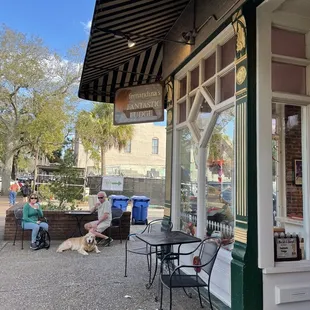 a man and his dog sitting outside a restaurant