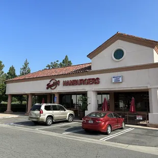 two cars parked in front of a restaurant
