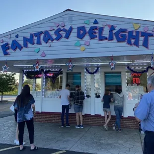 people standing outside of a candy shop